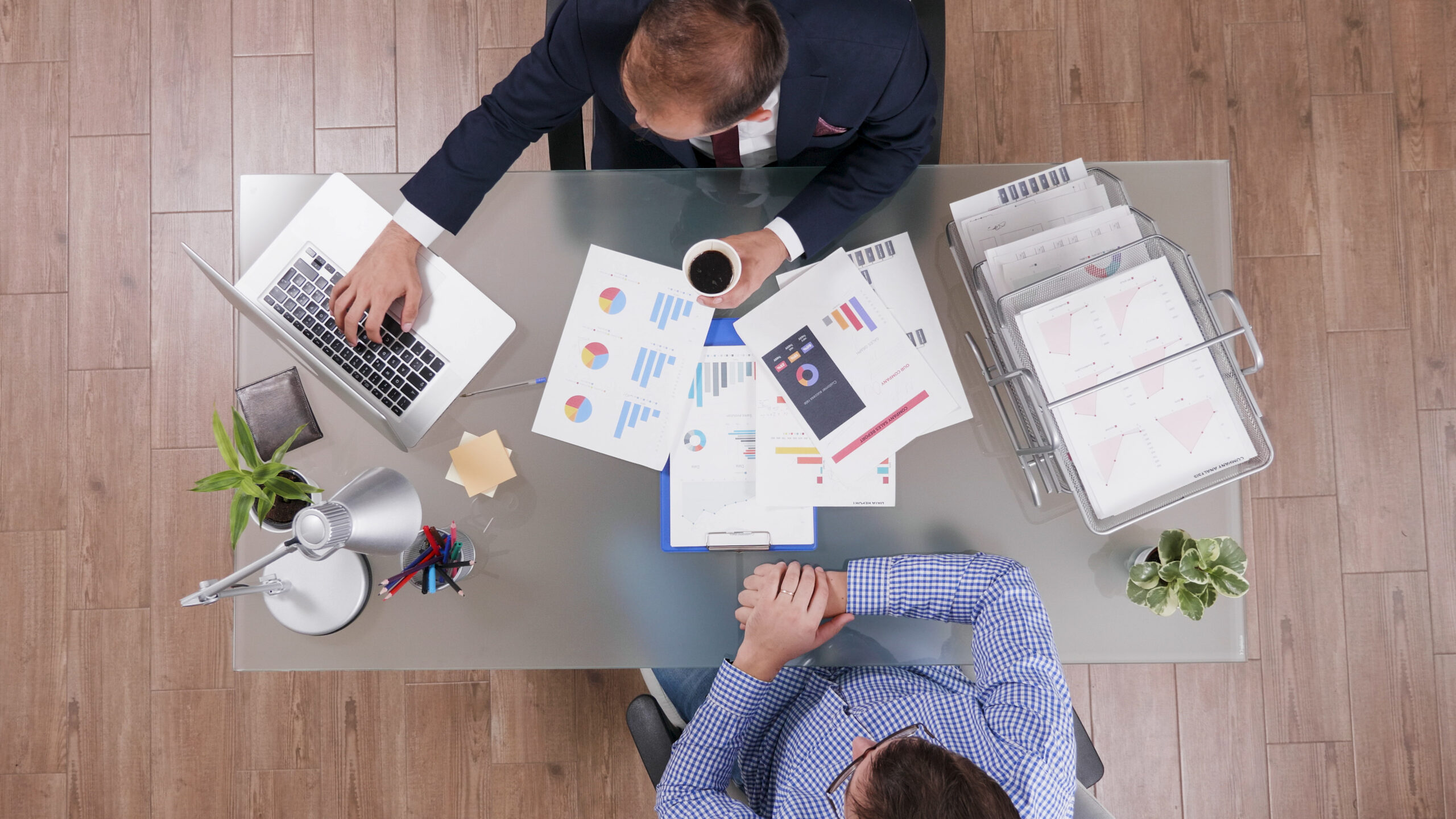 Top View Of Businessmen Discussing Company Strategy Analyzing Marketing Paperwork Top View Of Businessmen Discussing Company Strategy Analyzing Marketing Paperwork