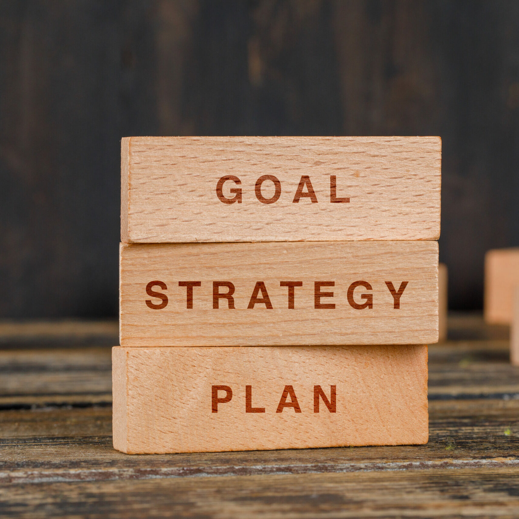 Business and marketing concept with wooden blocks on wooden background side view.