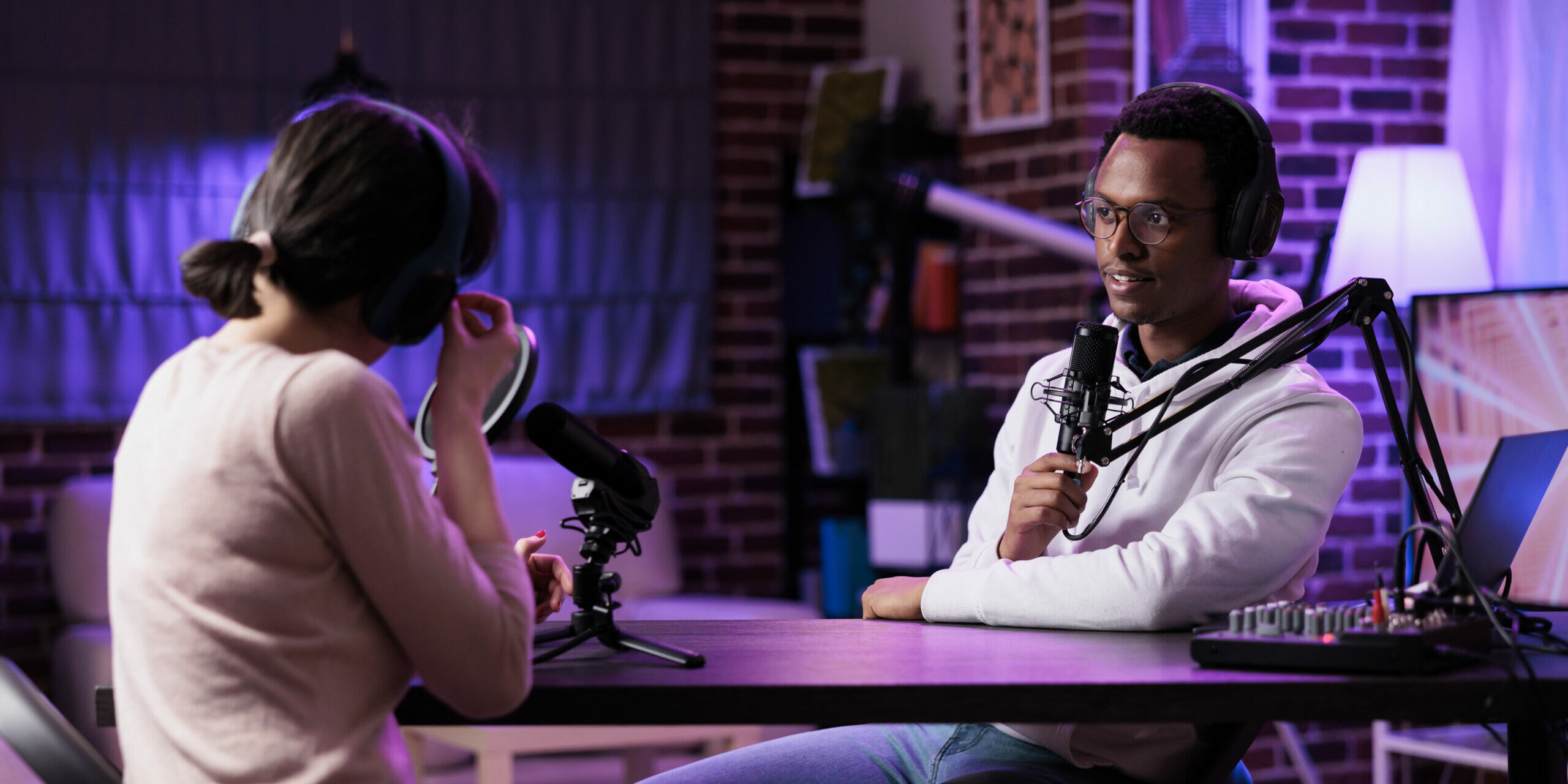 Diverse team of blog creators streaming podcast episode with recording and sound equipment. Man and woman meeting in studio to broadcast live discussion online, internet channel vlog.